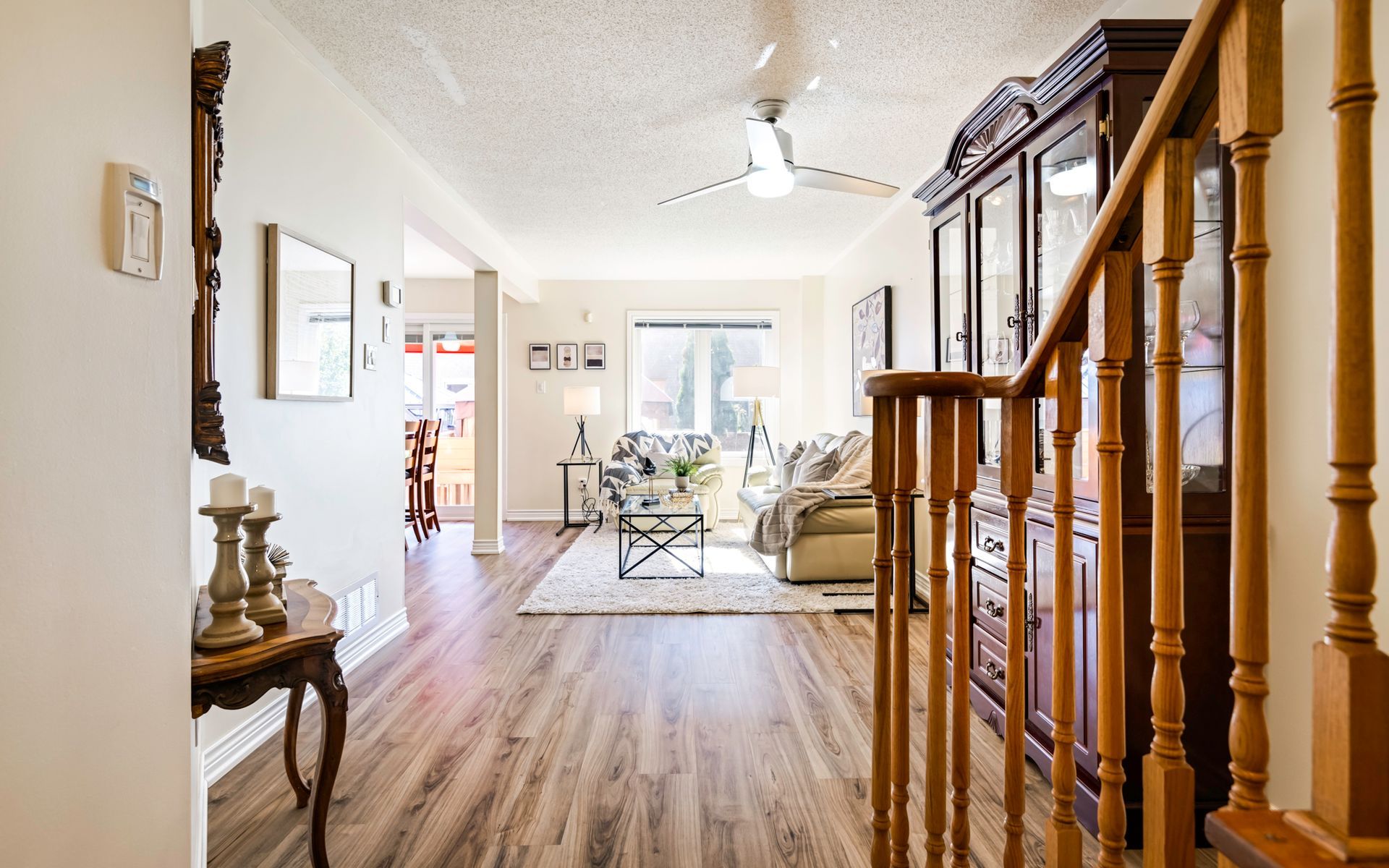 A living room with hardwood floors and a staircase leading to the second floor.