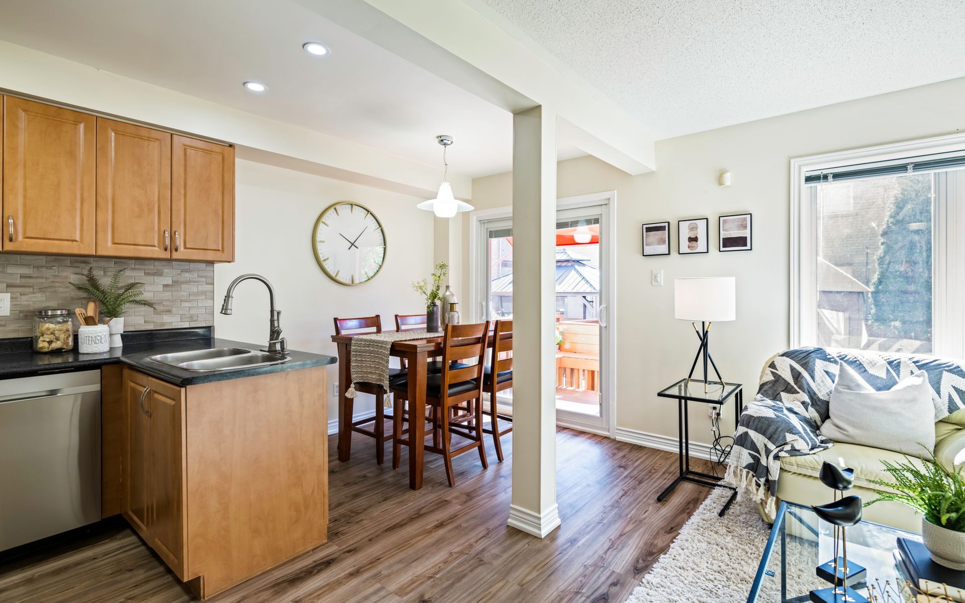 A kitchen and dining room in a house with a clock on the wall.