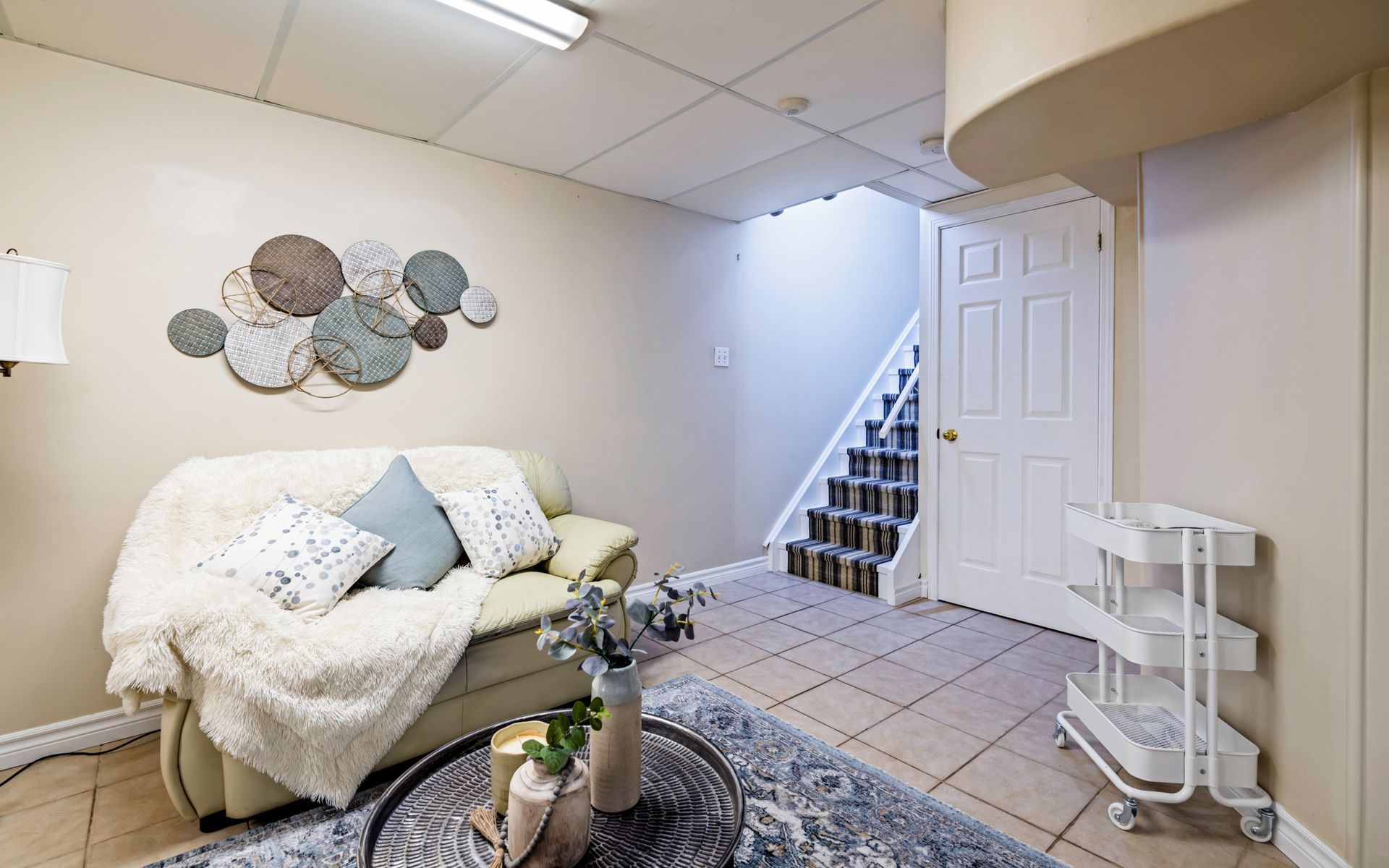 A living room with a couch , coffee table , and stairs.
