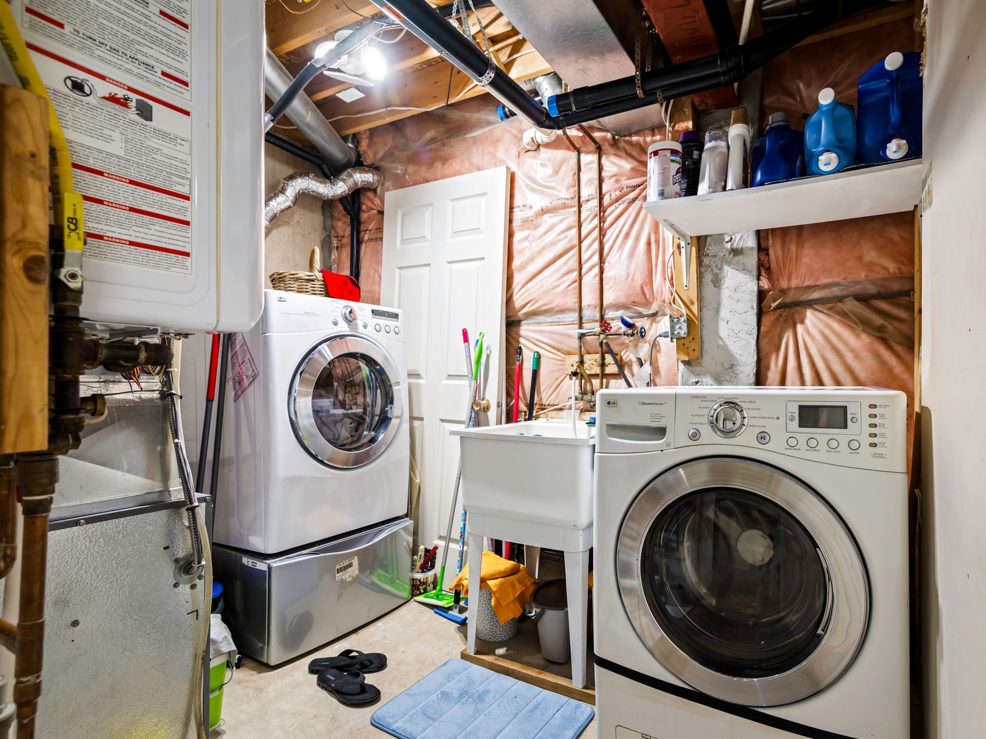 A laundry room with a washer and dryer and a sink.