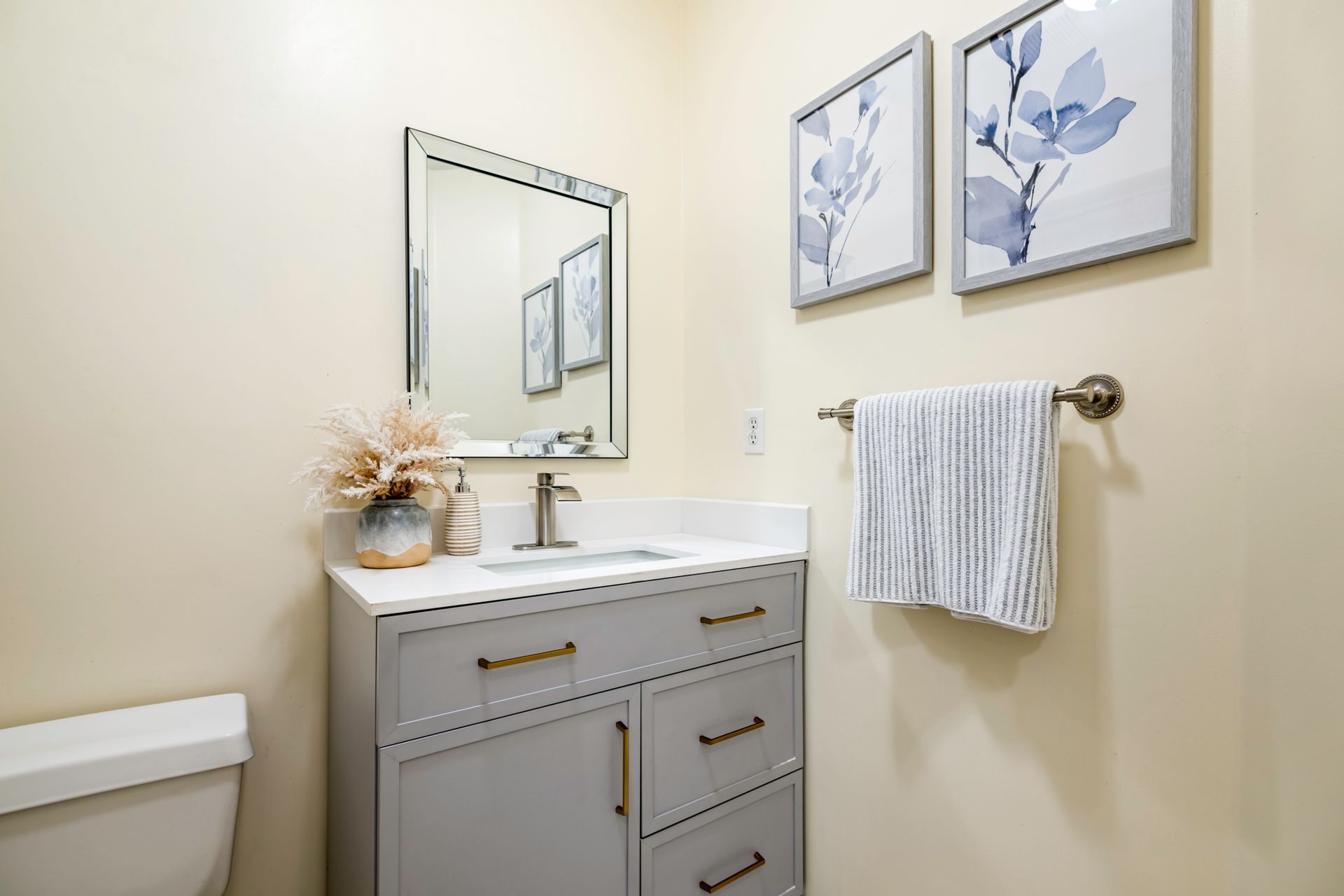 A bathroom with a sink , toilet and mirror.