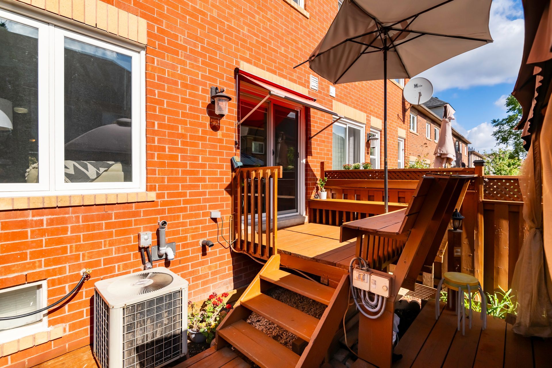 A brick house with a wooden deck and stairs