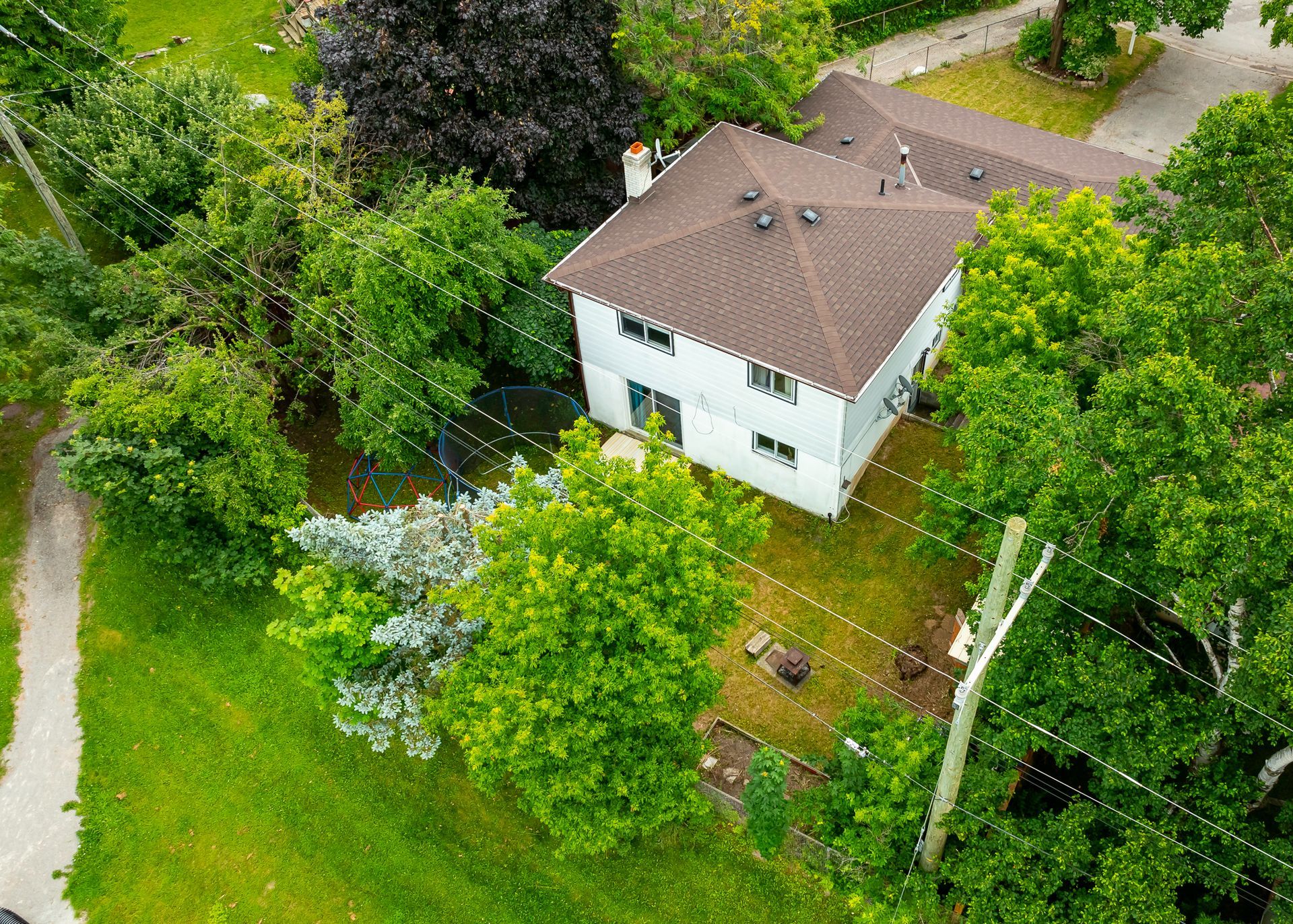 An aerial view of a house surrounded by trees and grass.
