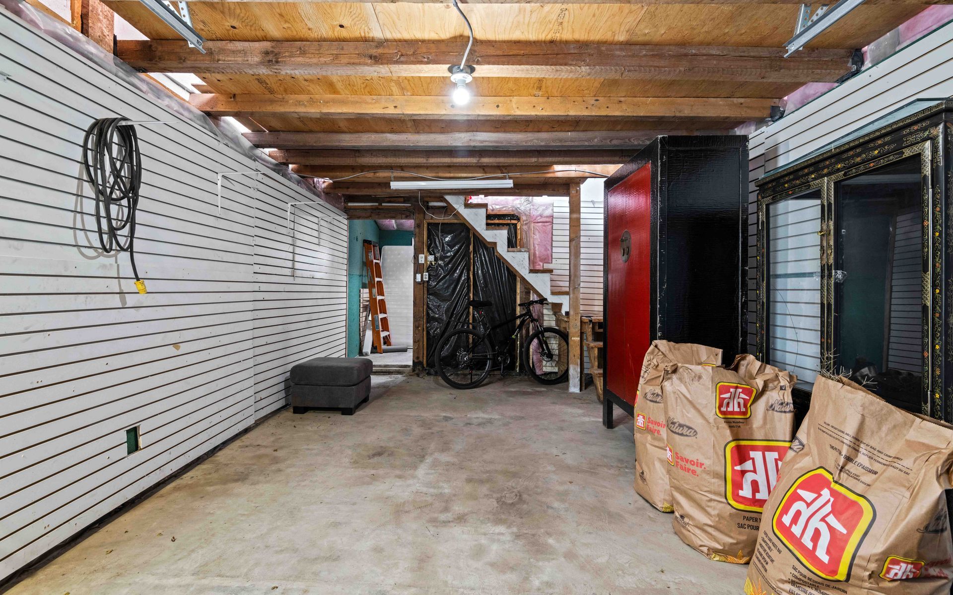 a large empty garage with bags of charcoal on the floor .