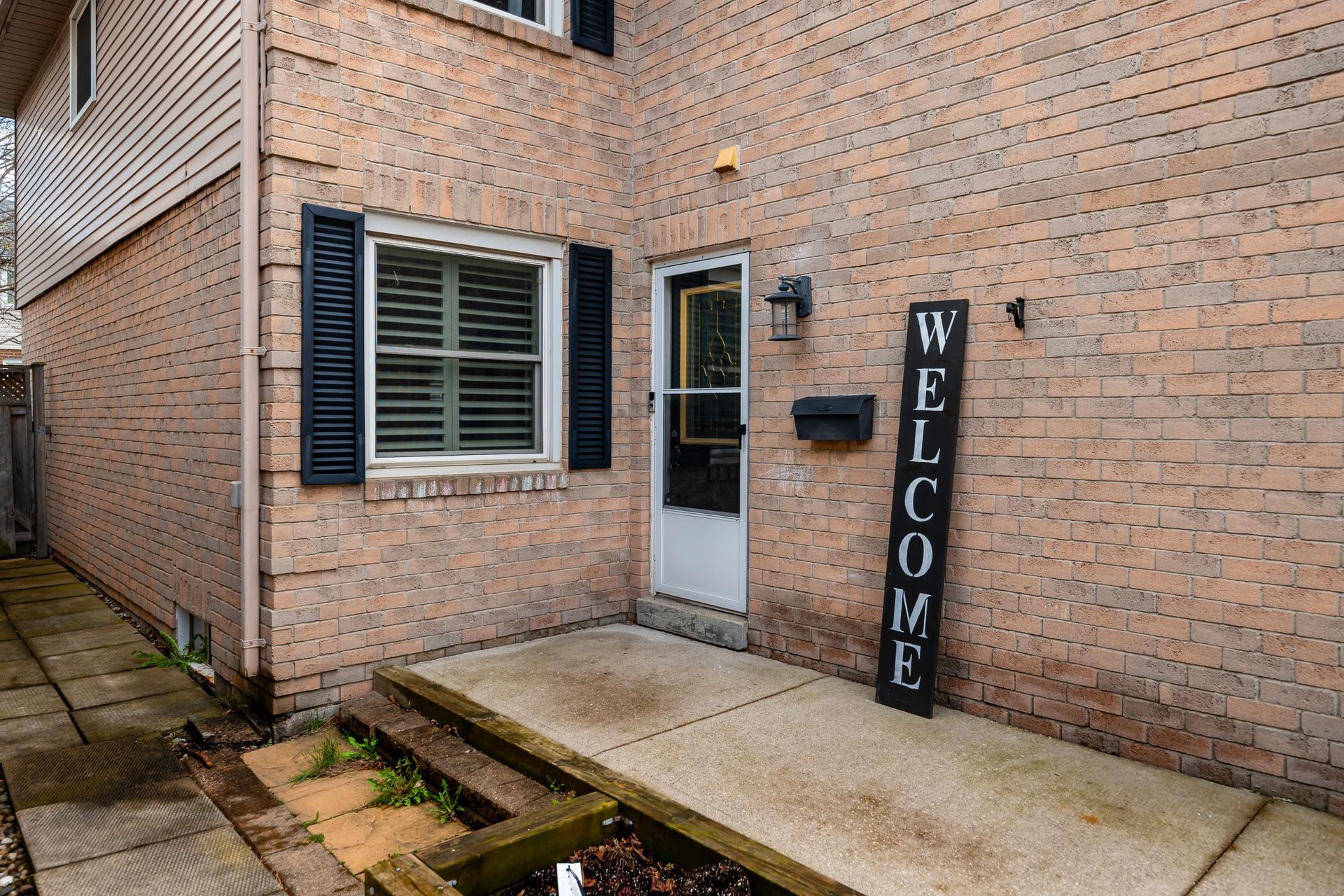 A brick house with a welcome sign in front of it.