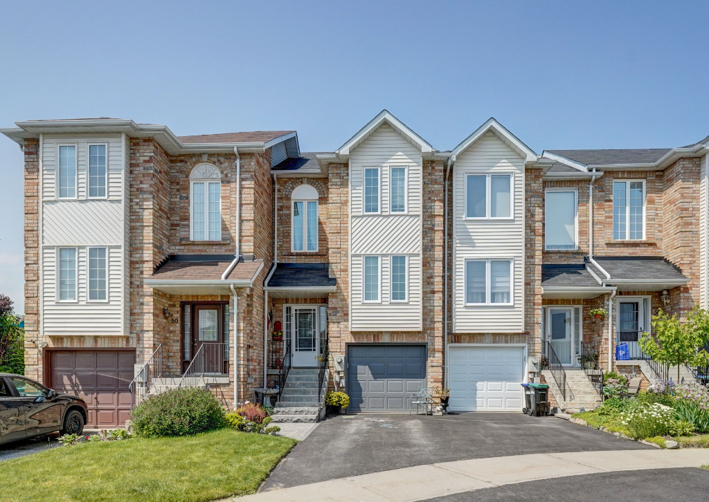 A row of houses with a car parked in front of them.
