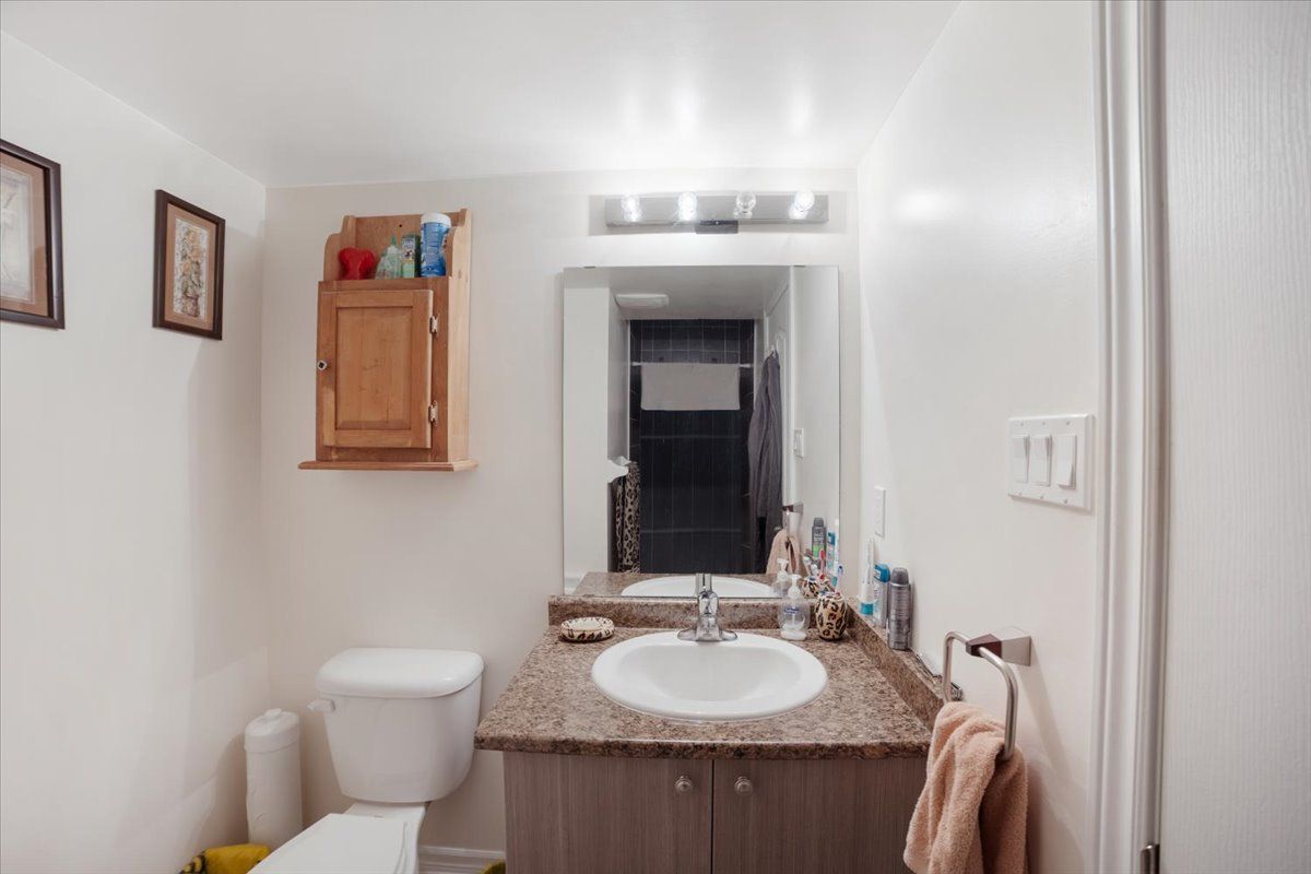 A bathroom with a sink , toilet and mirror.