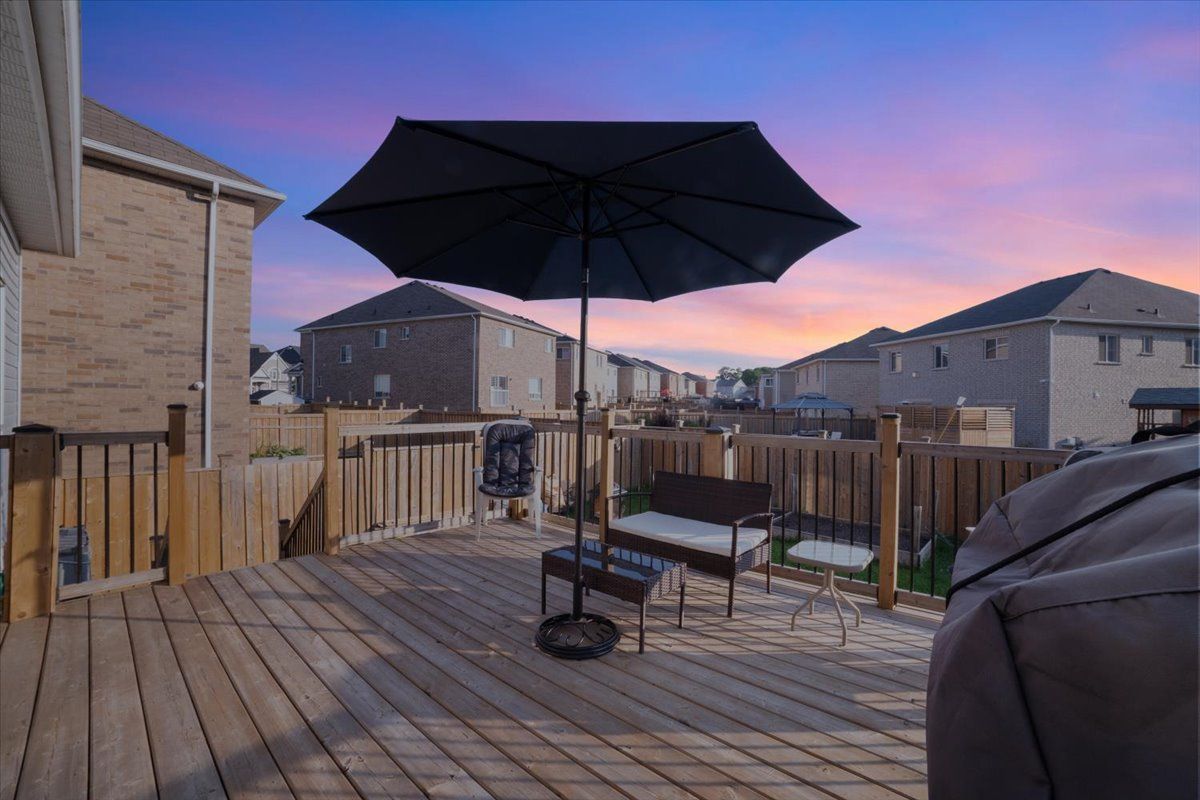 A black umbrella is sitting on a wooden deck.