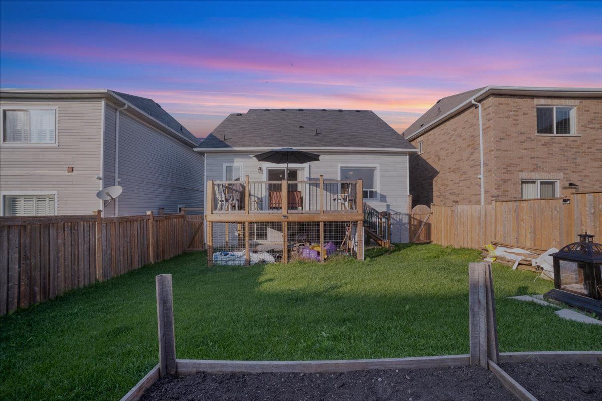 The backyard of a house with a deck and a fence.