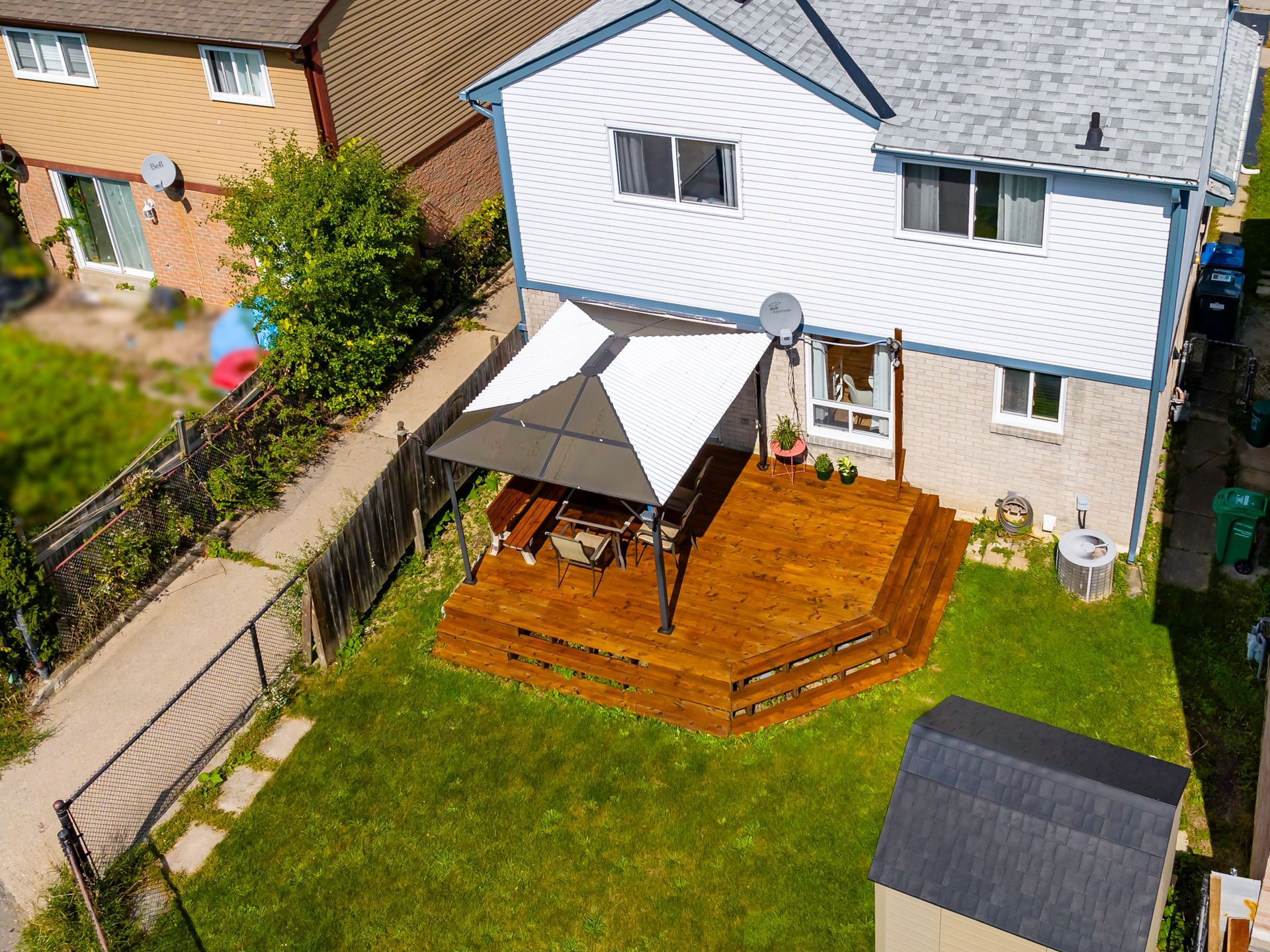 An aerial view of a house with a wooden deck and umbrella.