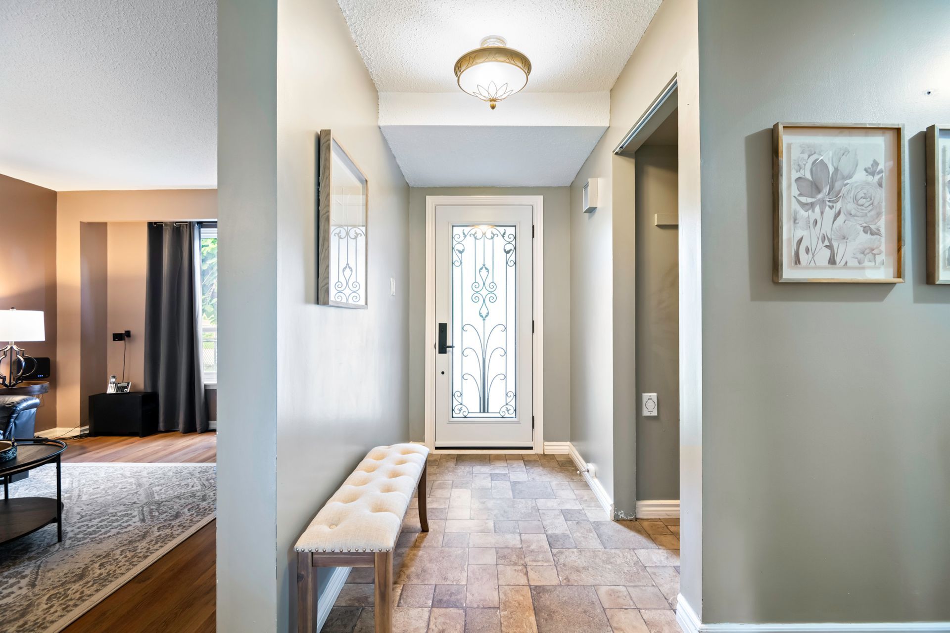 A hallway in a house with a bench and a mirror.