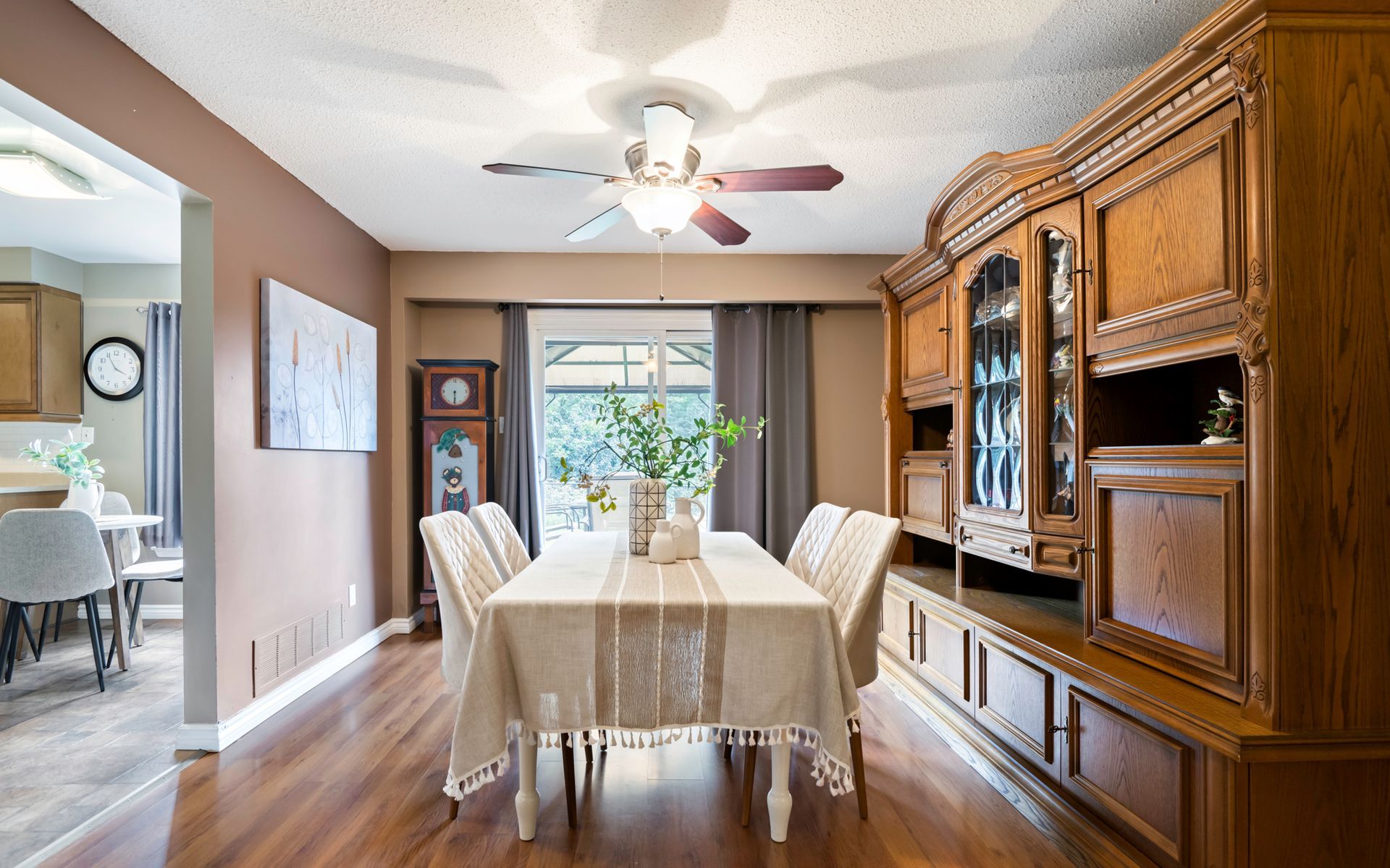 A dining room with a table and chairs and a ceiling fan.