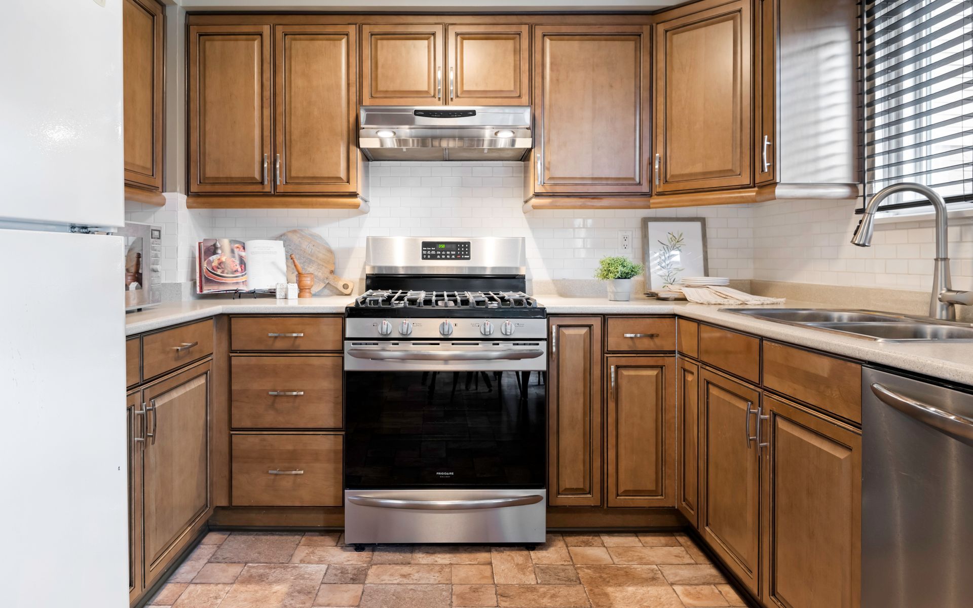 A kitchen with stainless steel appliances and wooden cabinets.