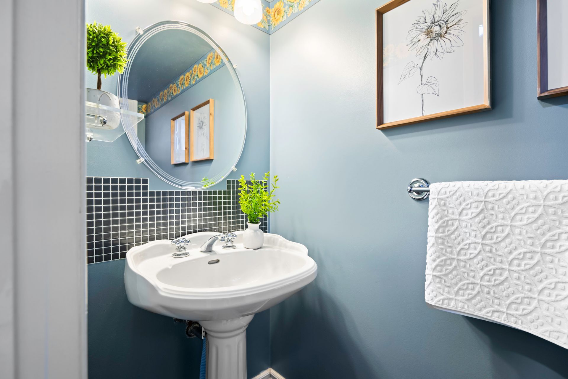 A bathroom with a sink , mirror and towel rack.
