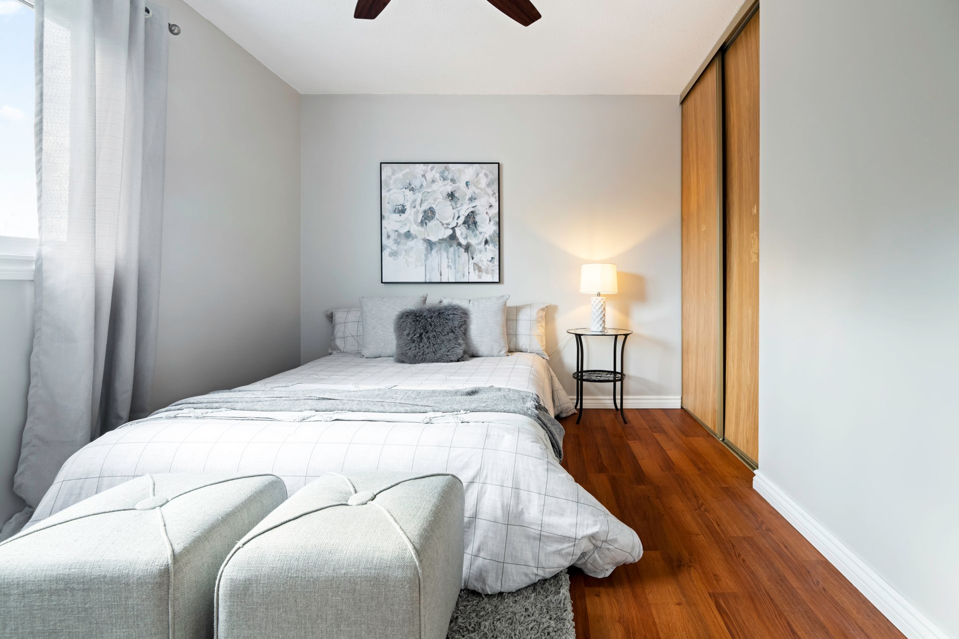 A bedroom with a bed and a ceiling fan.