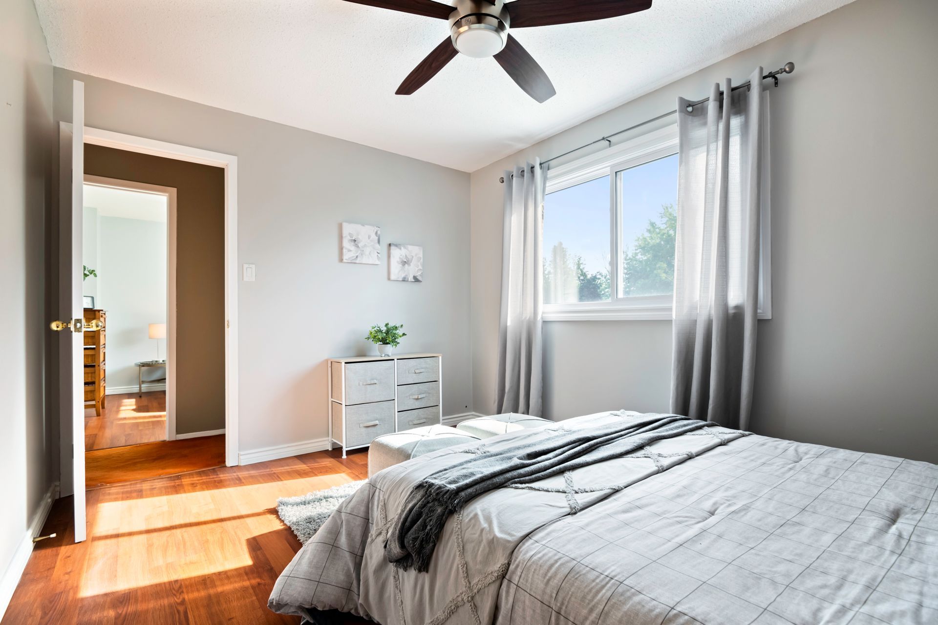 A bedroom with a bed and a ceiling fan.