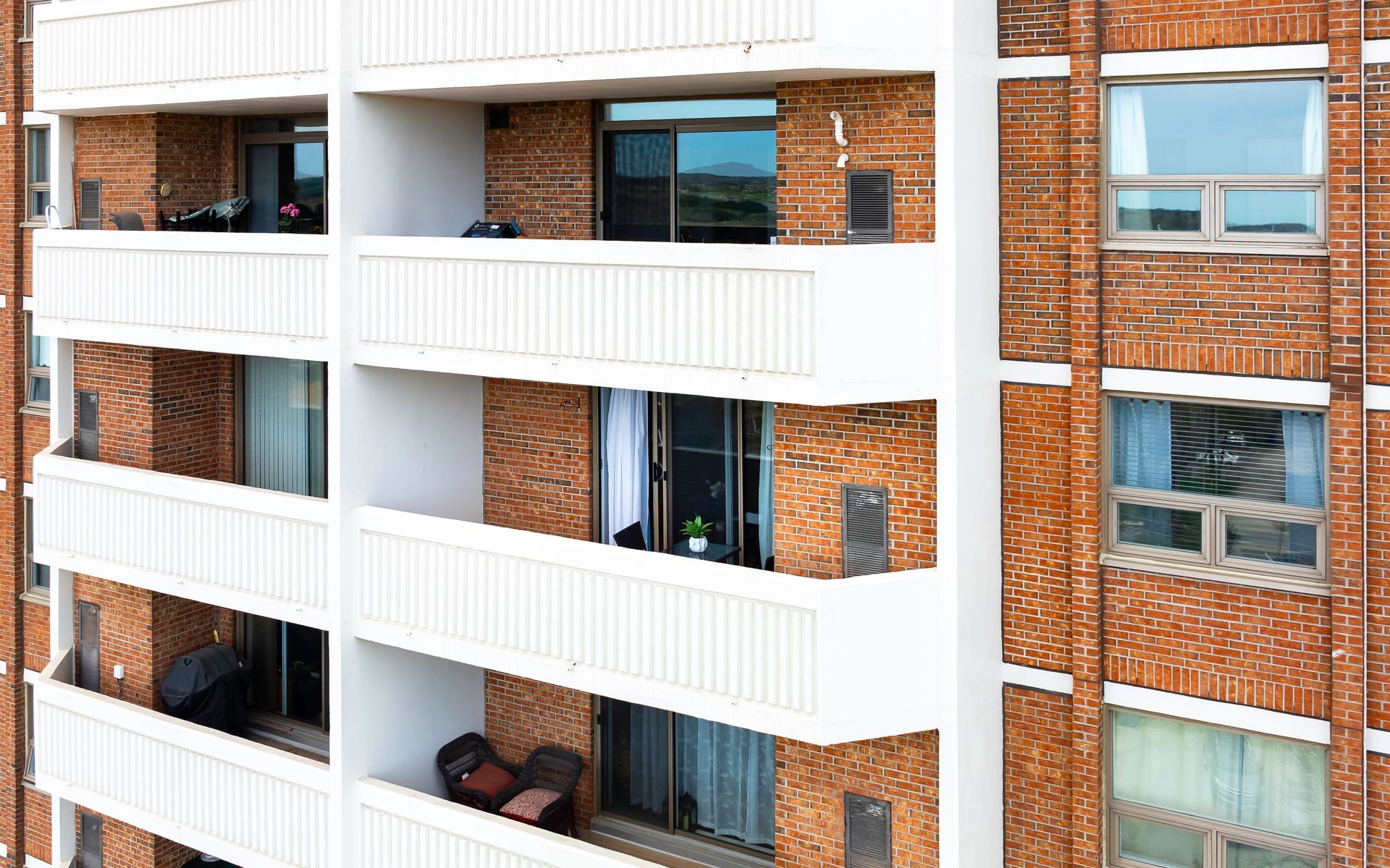 A brick building with a lot of balconies and windows.