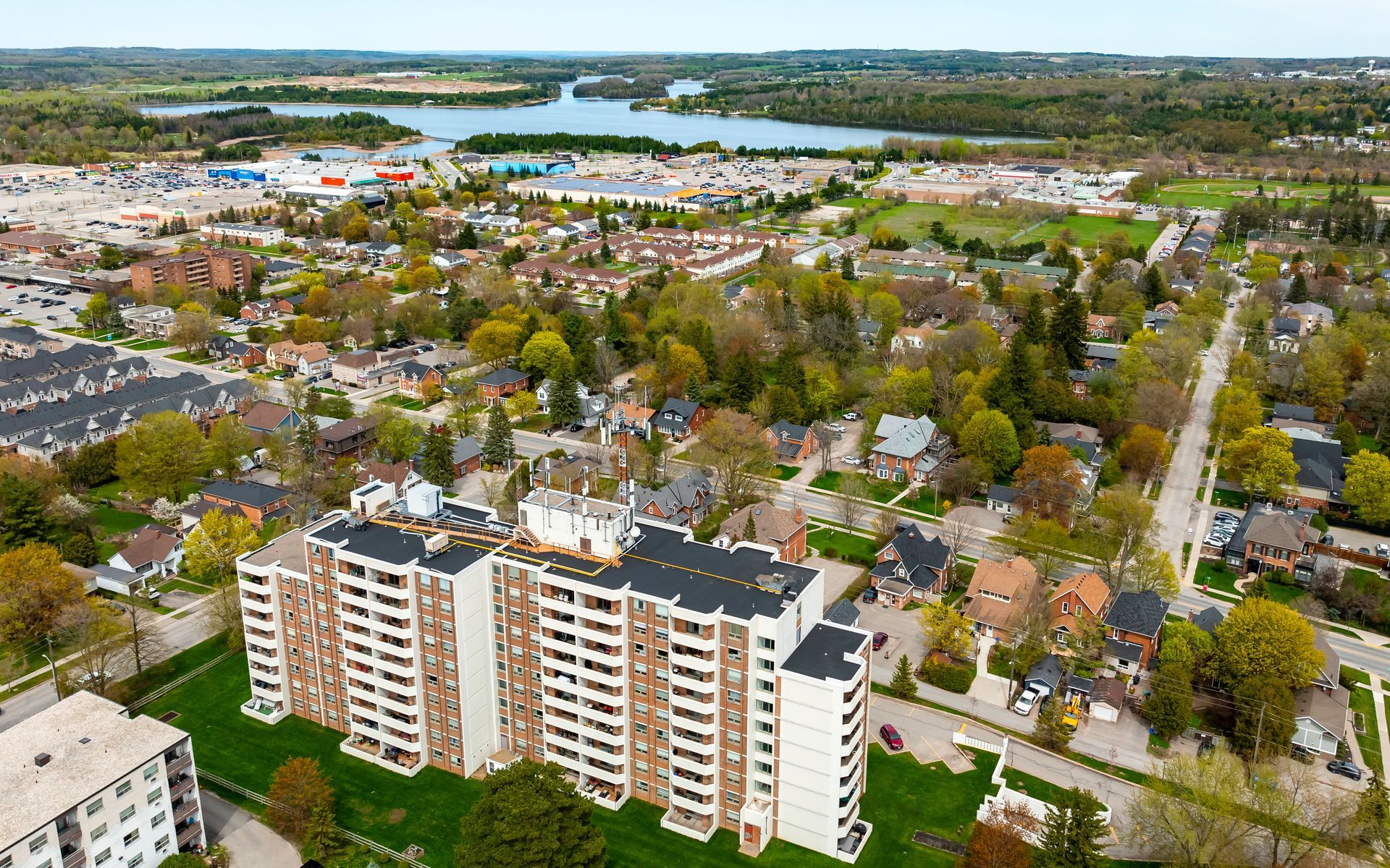 An aerial view of a city with tall buildings and a lake in the background.