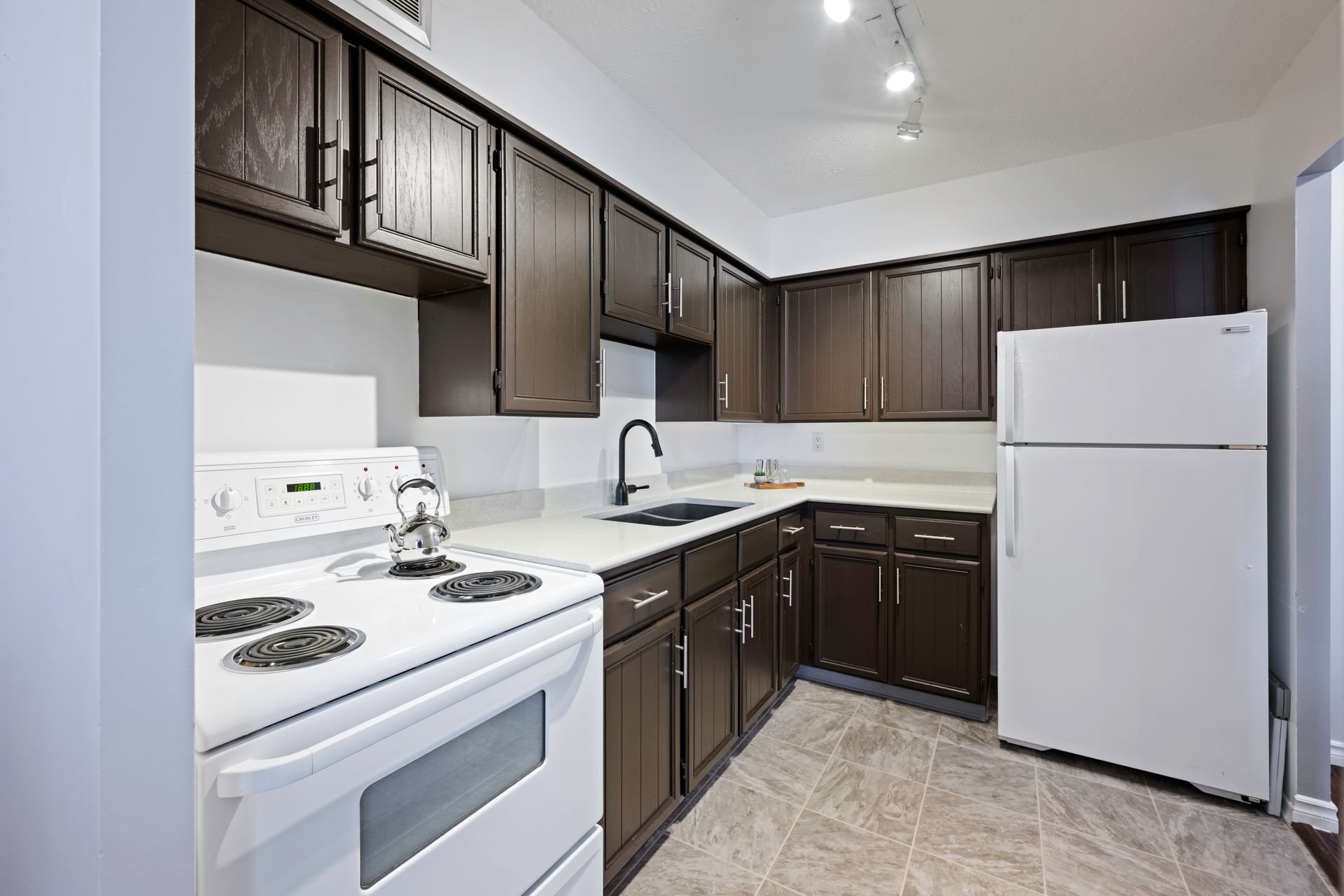 A kitchen with white appliances and brown cabinets