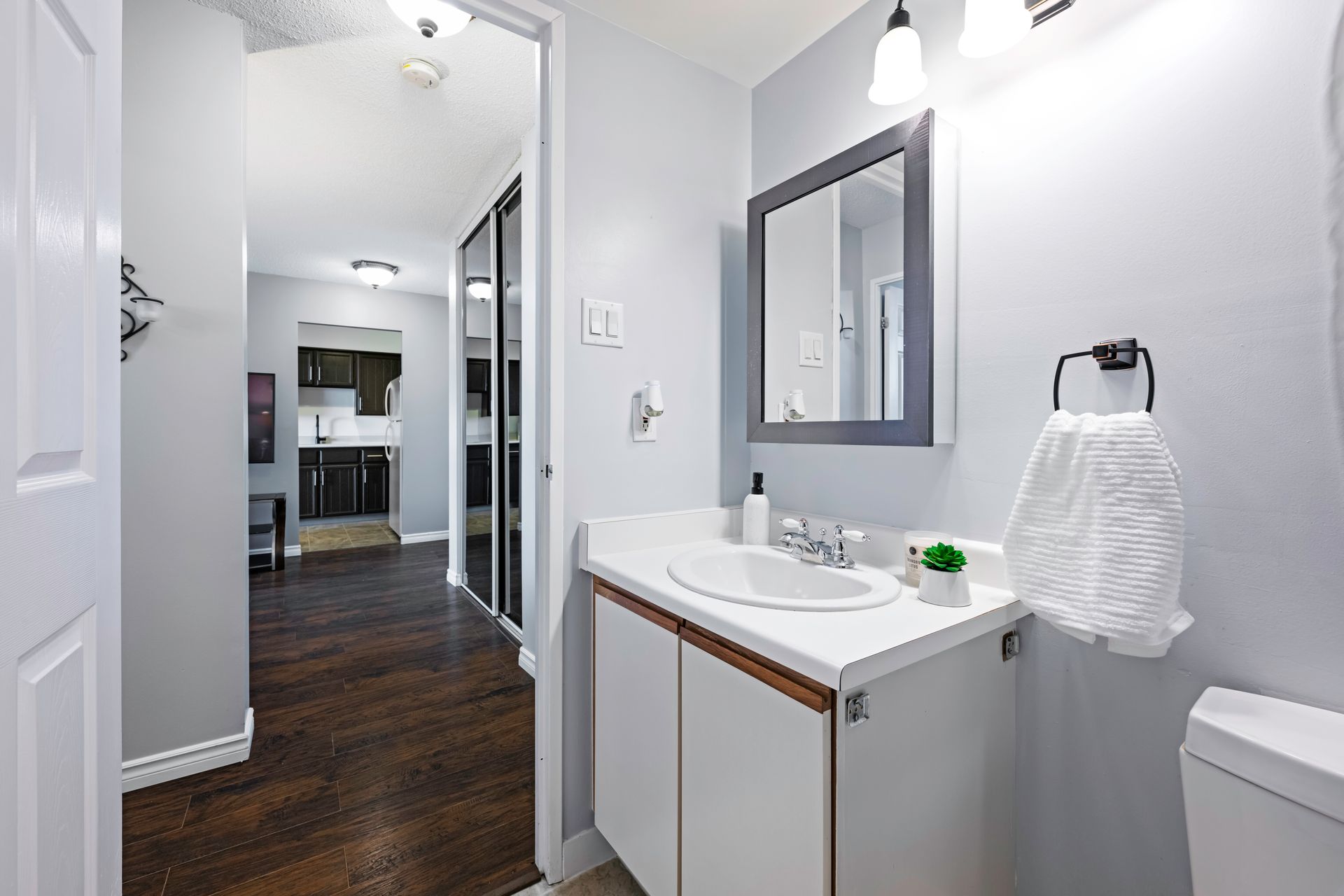 A bathroom with a sink , mirror and toilet.