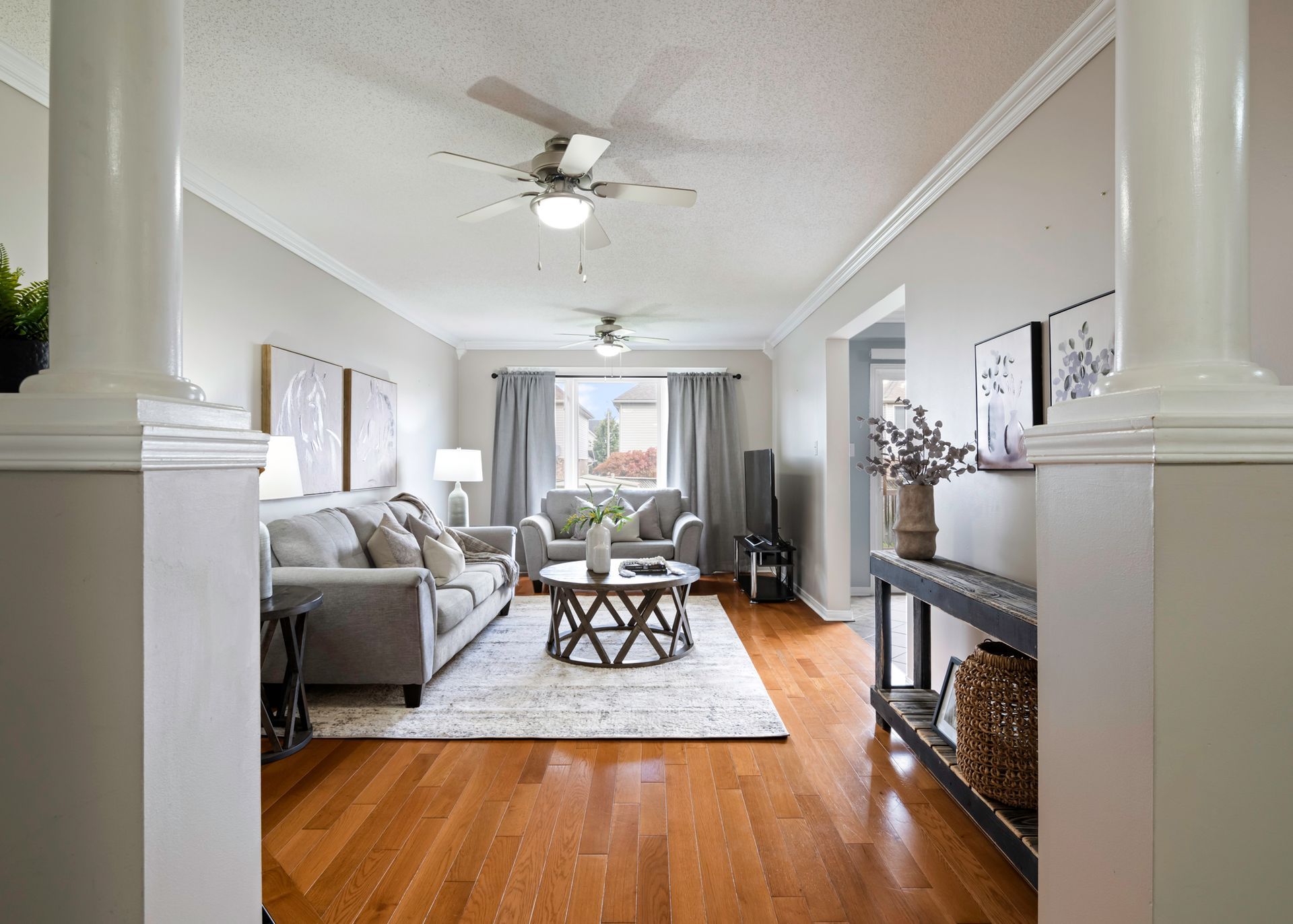 A living room with hardwood floors and a ceiling fan.
