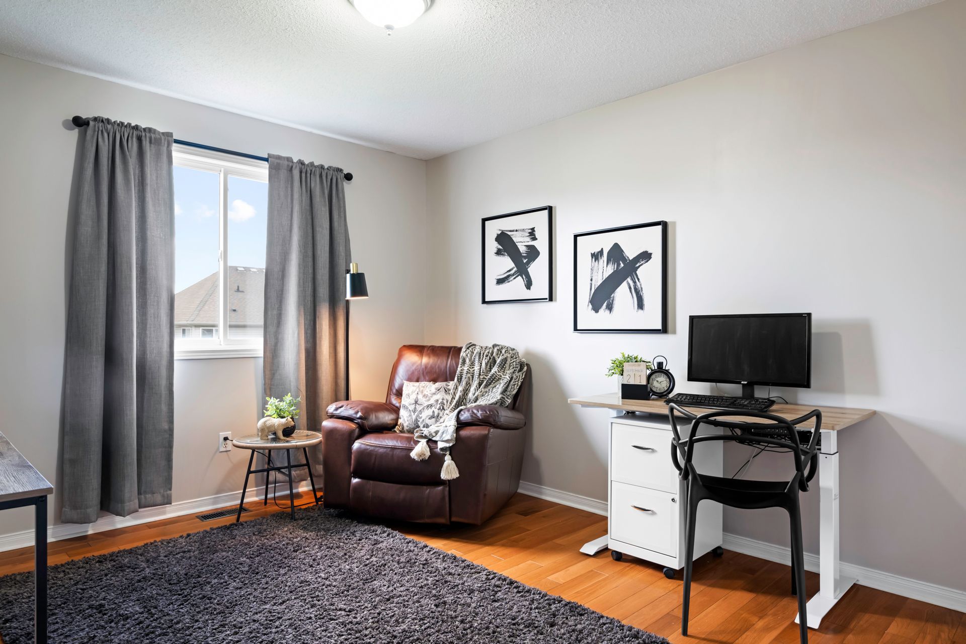A living room with a chair , desk and computer.