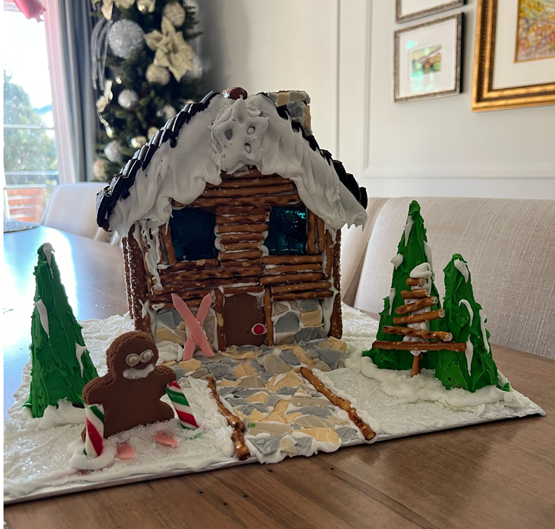 A gingerbread house with trees and a gingerbread man