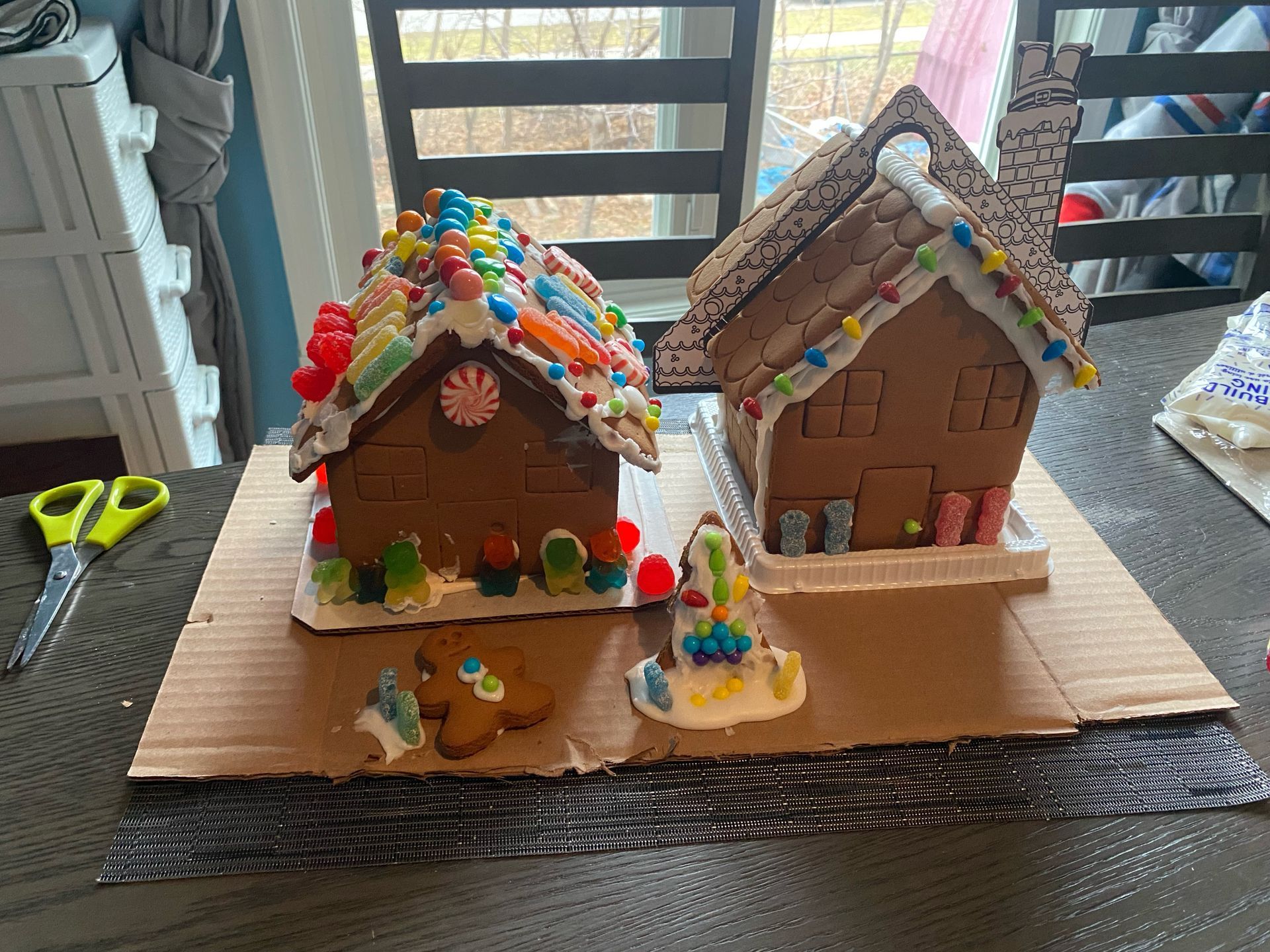 Two gingerbread houses are sitting on top of a cardboard box on a table.