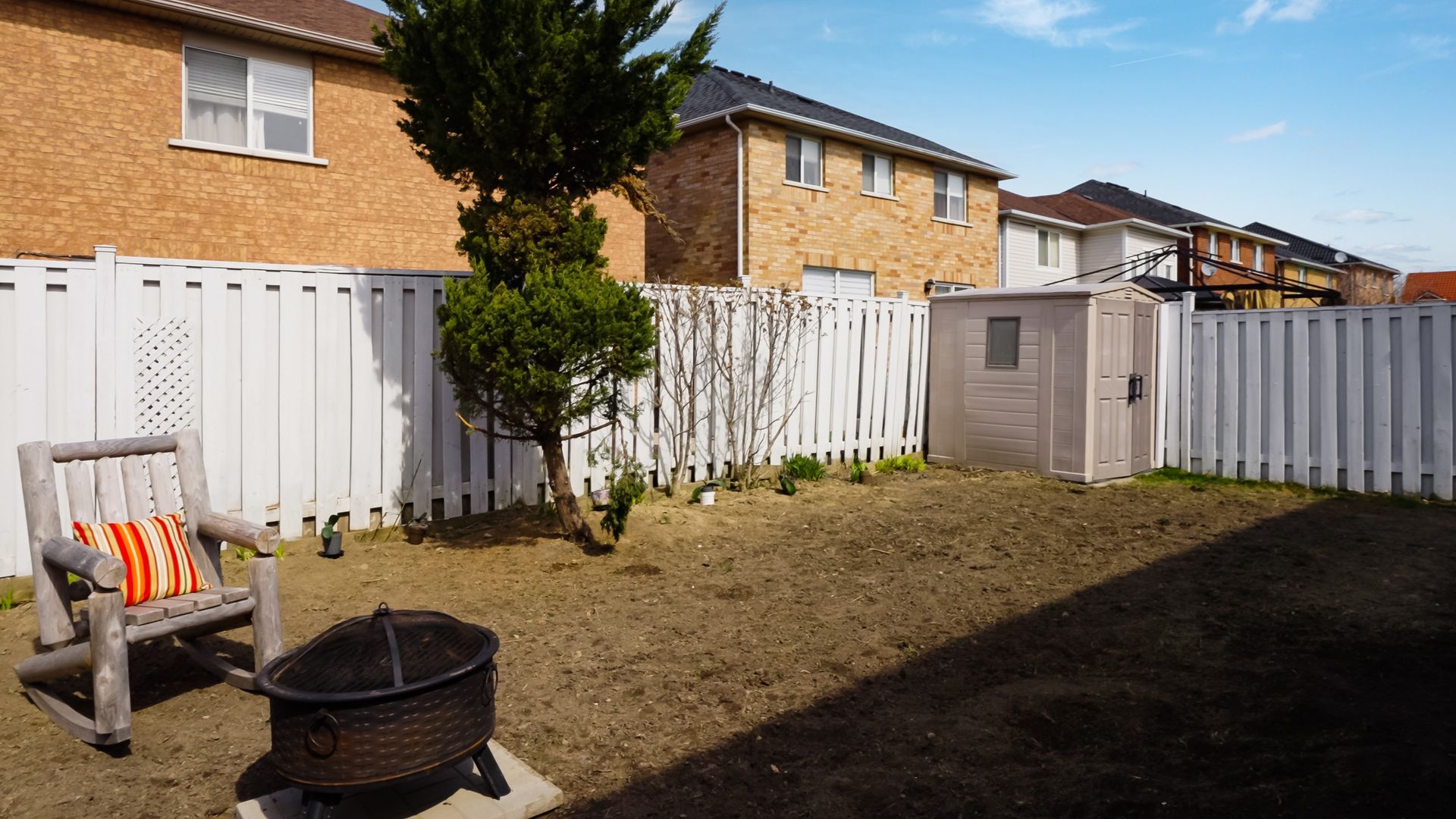 There is a fire pit in the backyard of a house.