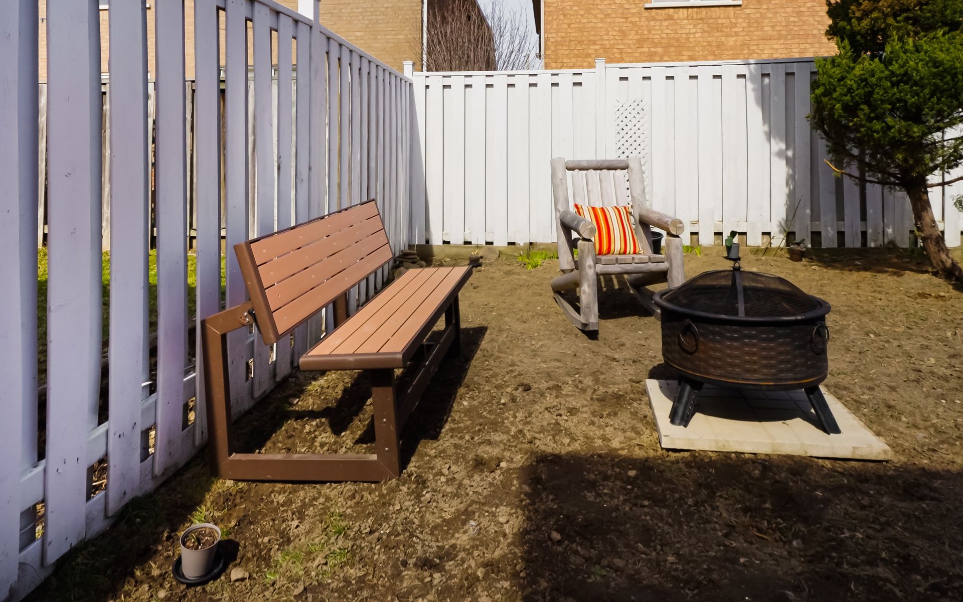 A backyard with a fire pit and a bench