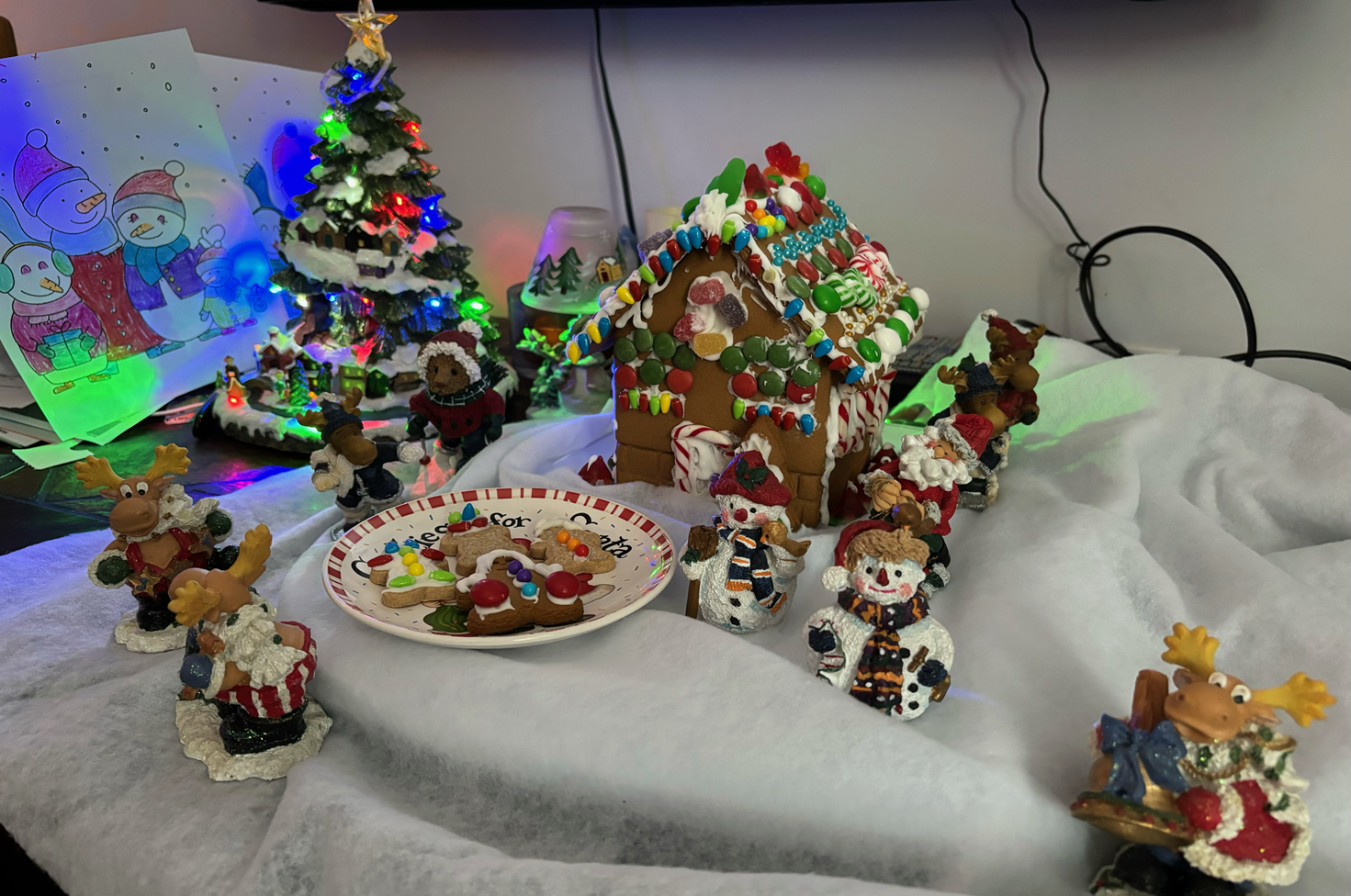 A table with a gingerbread house and christmas decorations on it
