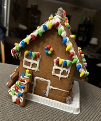 A gingerbread house with christmas lights on the roof