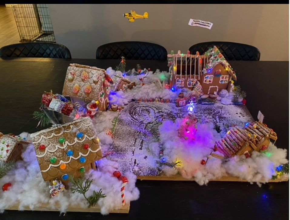 A table topped with gingerbread houses decorated for christmas.