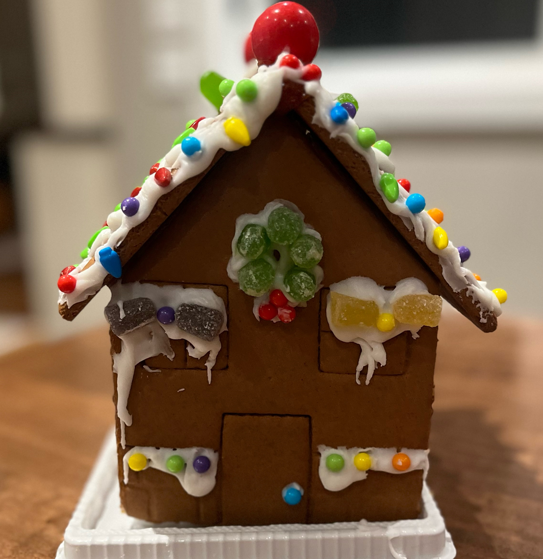 A small gingerbread house decorated with icing and sprinkles