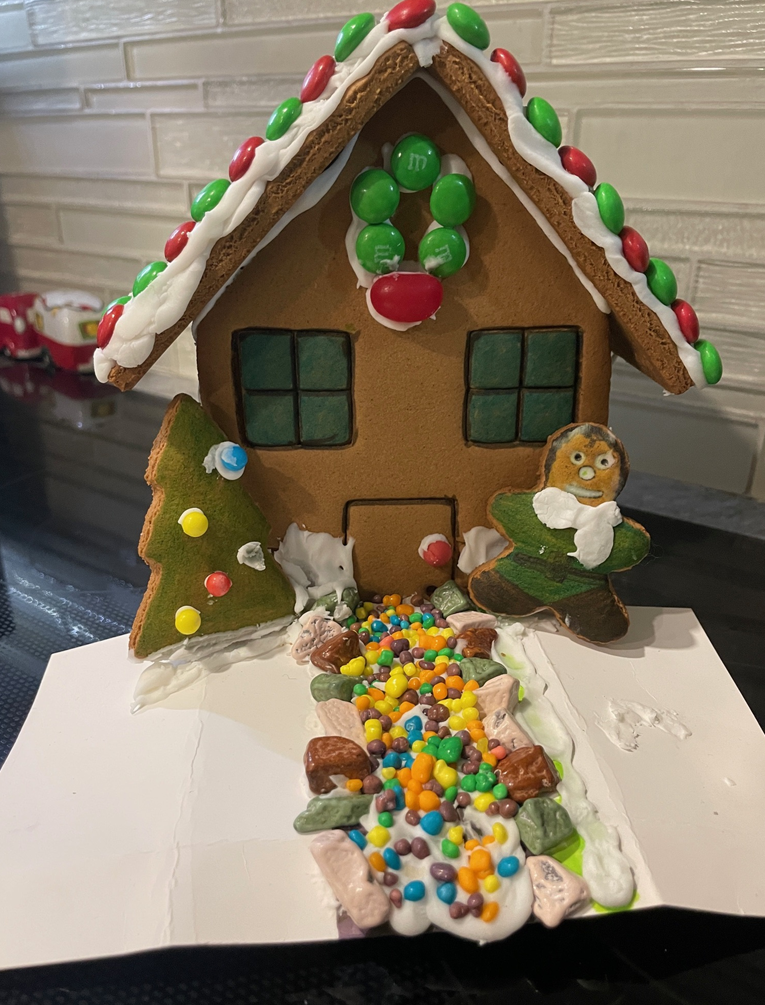 A gingerbread house is sitting on top of a card on a table.