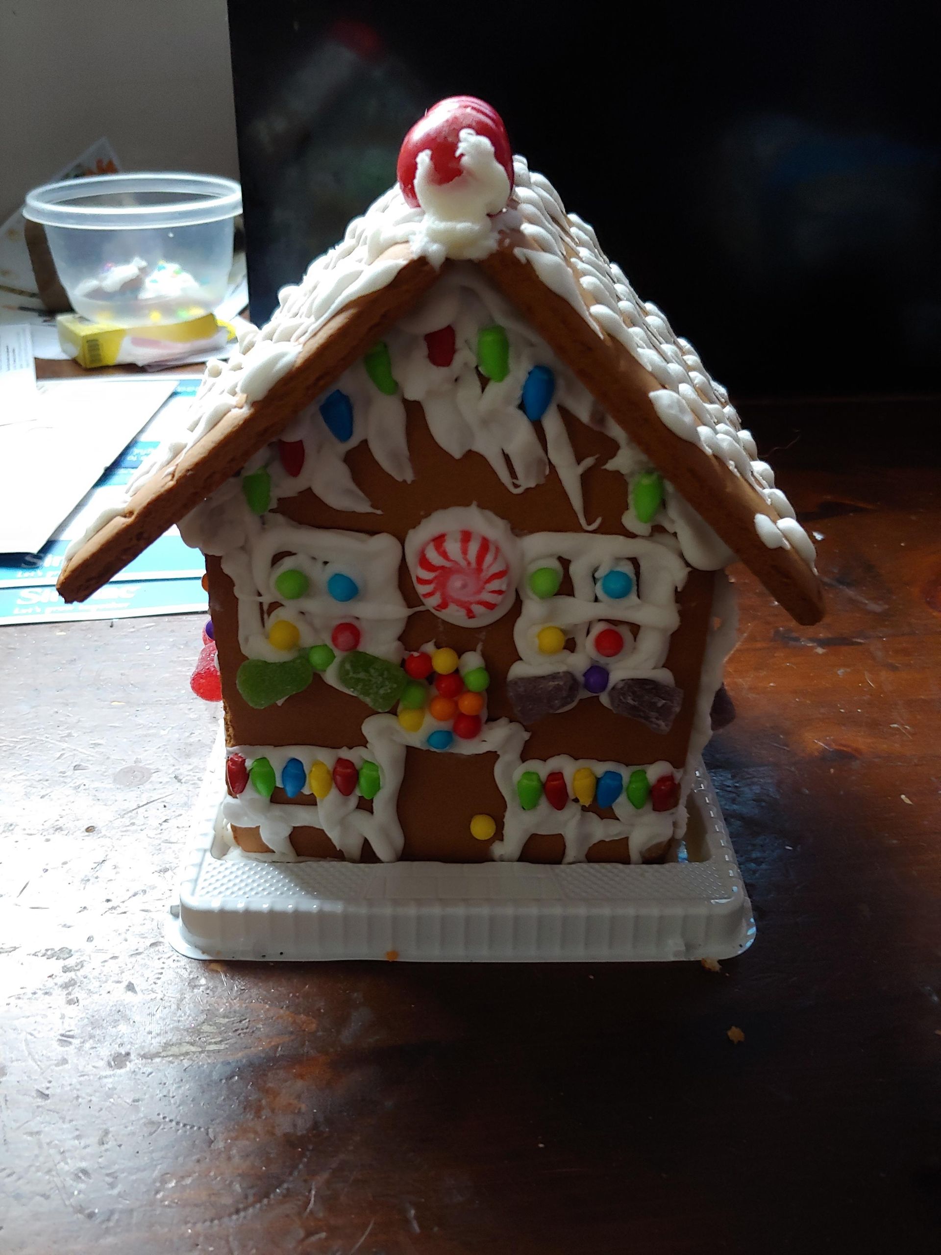 A small gingerbread house decorated with candy and icing