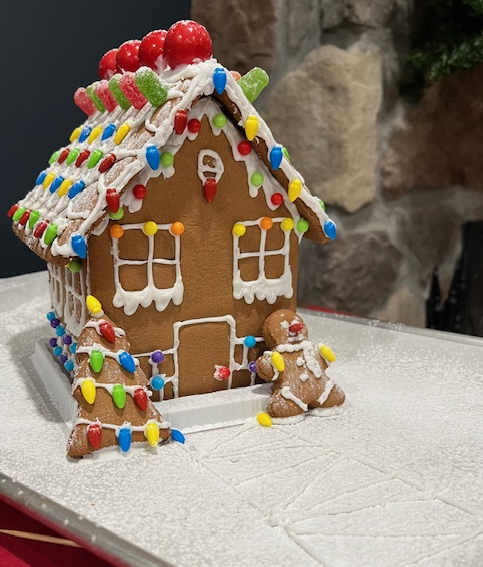 A gingerbread house with christmas lights on the roof