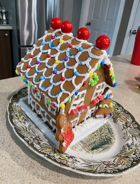 A gingerbread house is sitting on a plate on a counter