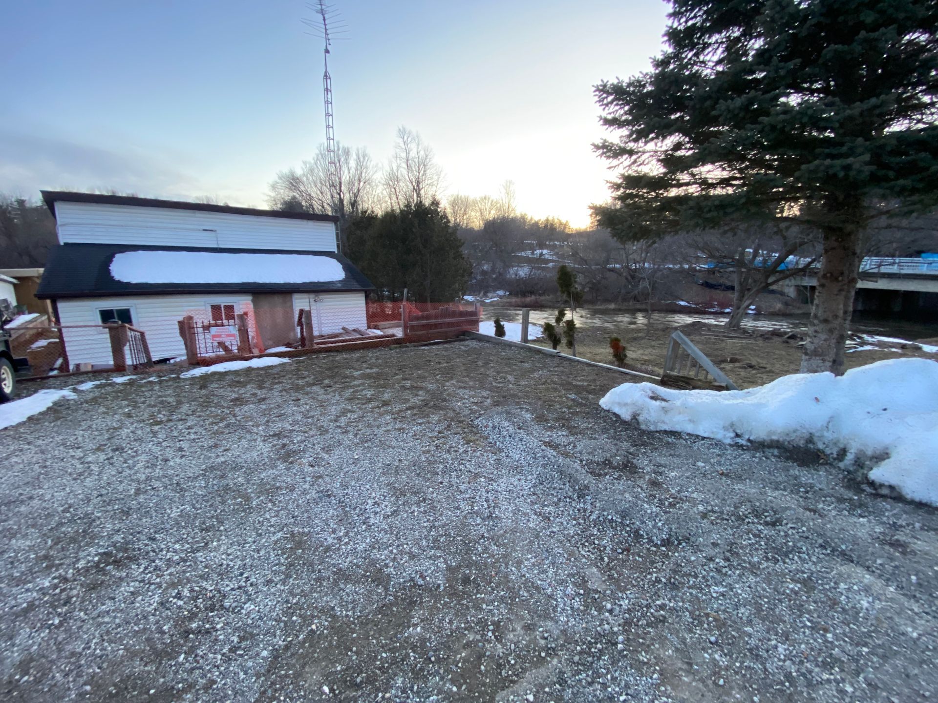 A large white building is sitting on top of a snow covered hill.