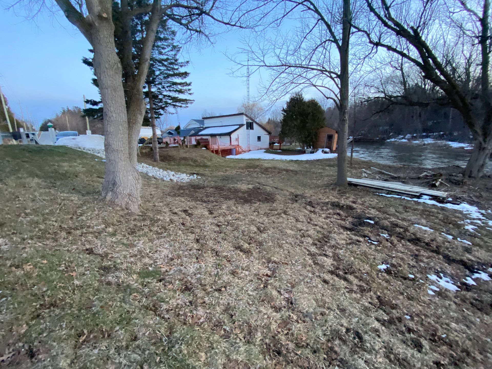 A house is sitting on a hill next to a river.