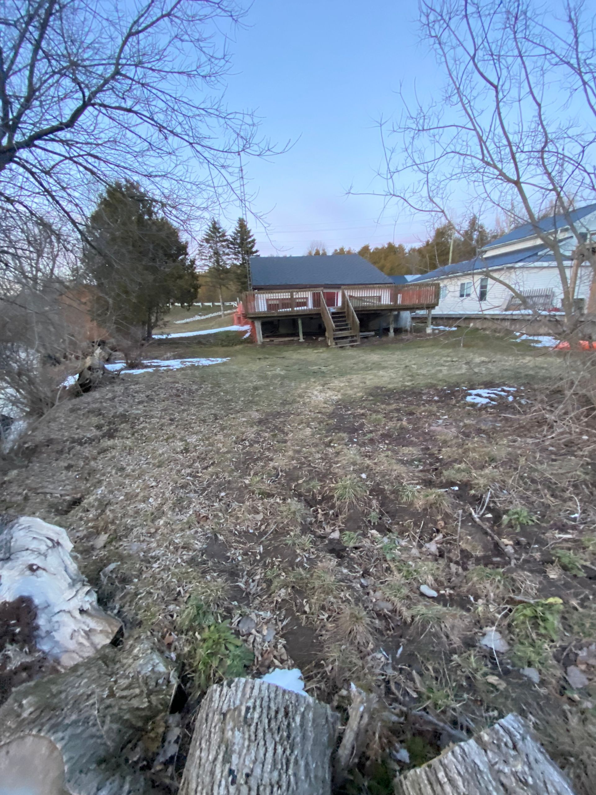 A house is sitting in the middle of a dirt field.