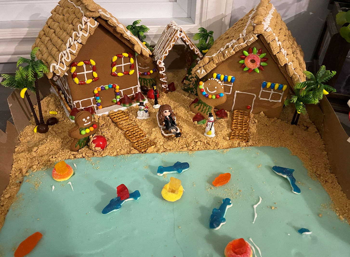 a gingerbread house is sitting on top of a table next to a body of water .