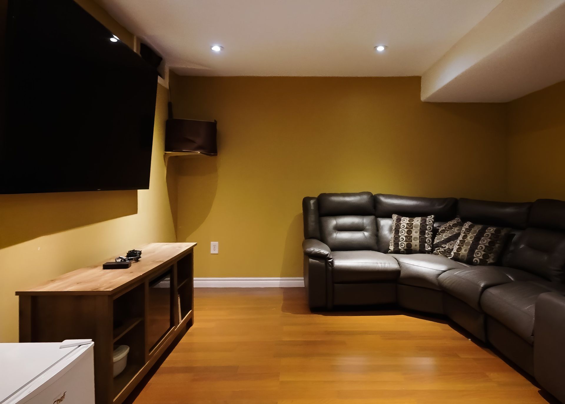 A living room with a sectional couch and a flat screen tv