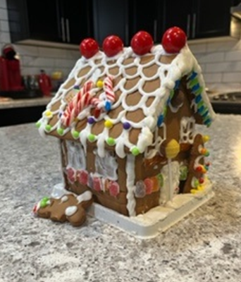 A gingerbread house with candy canes on top of it