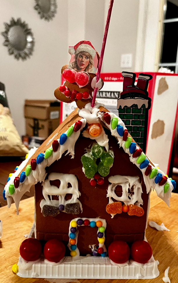 A gingerbread house decorated for christmas is sitting on a wooden table.