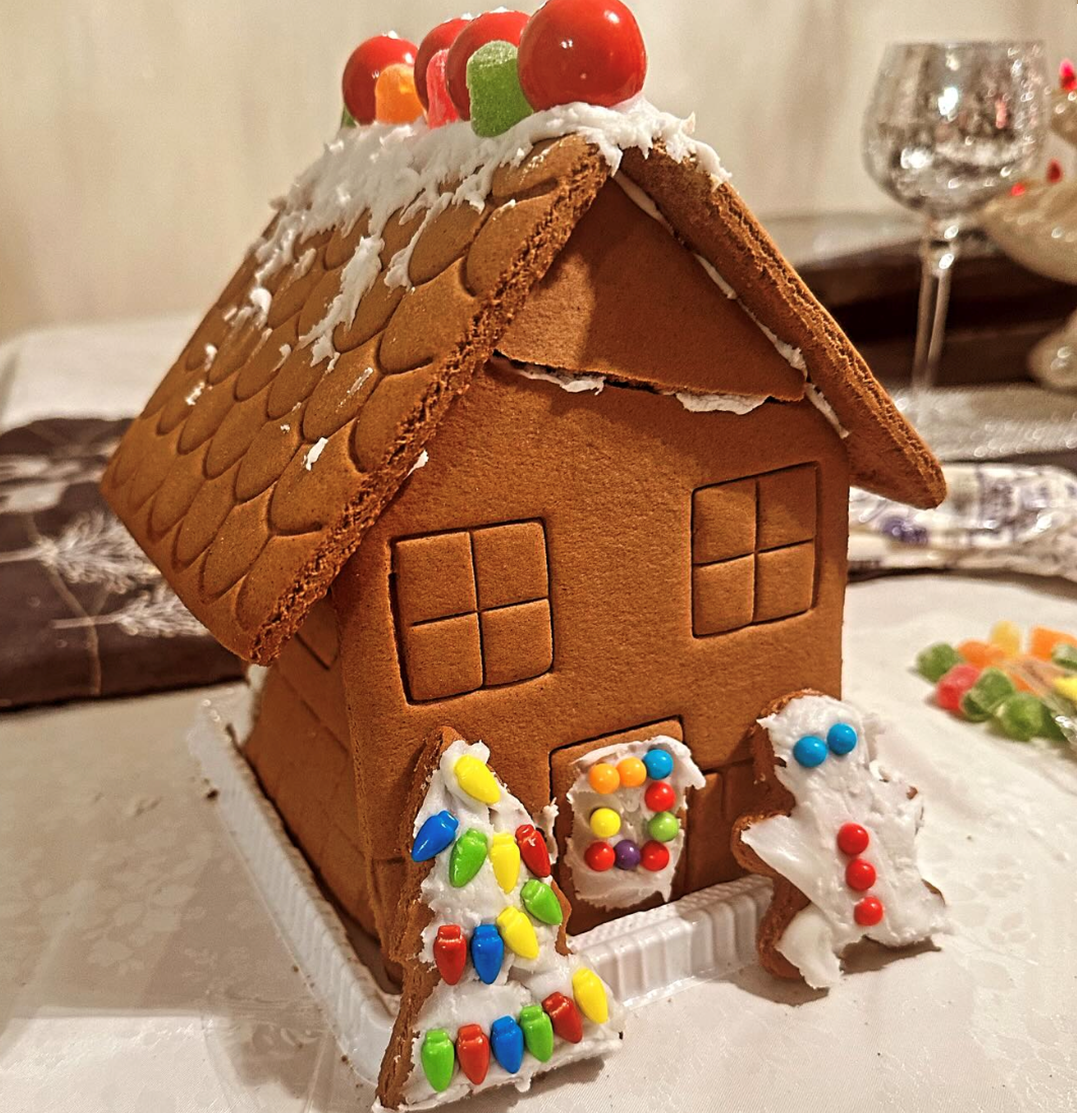 A gingerbread house with a christmas tree on the side