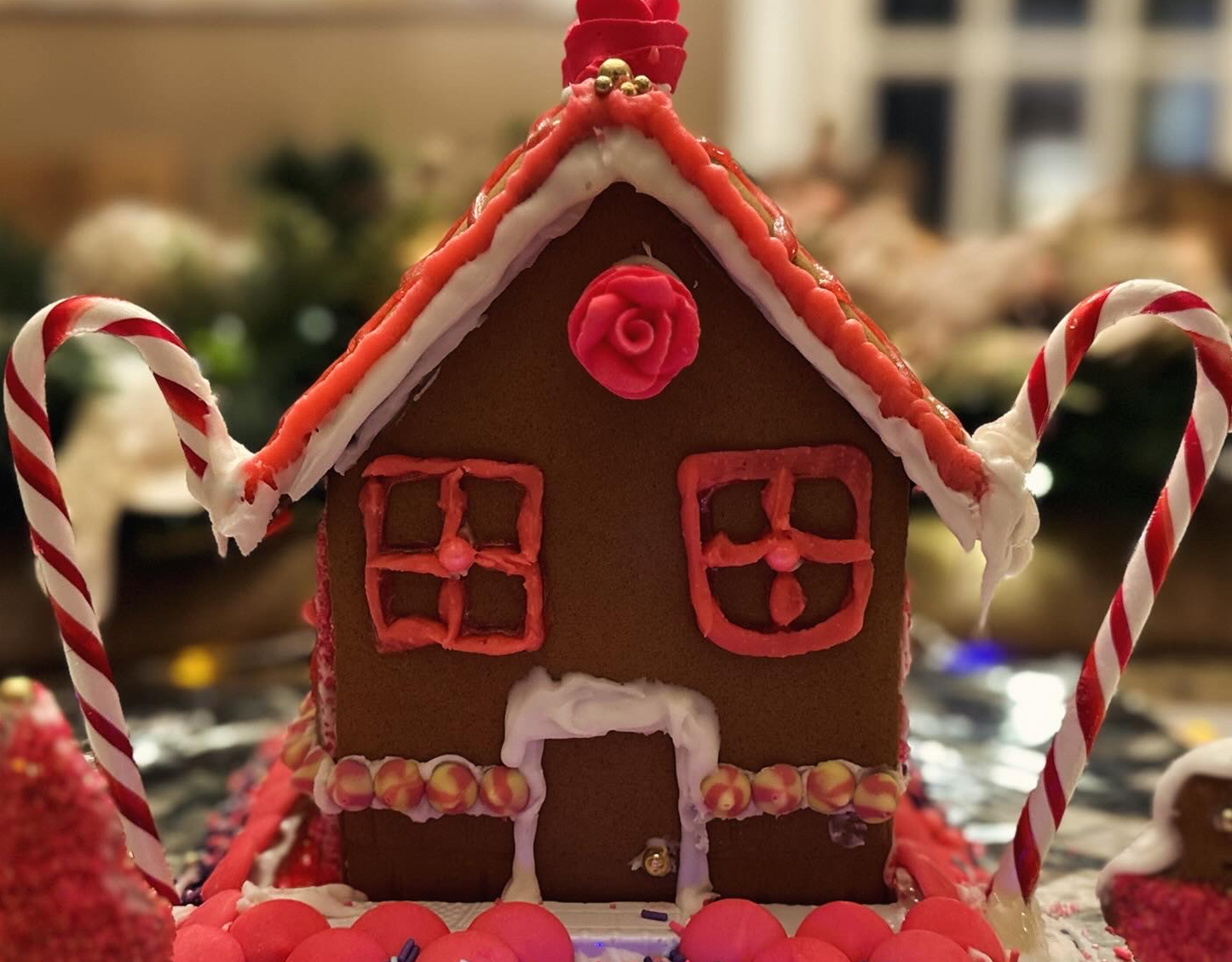 A gingerbread house with candy canes on top of it
