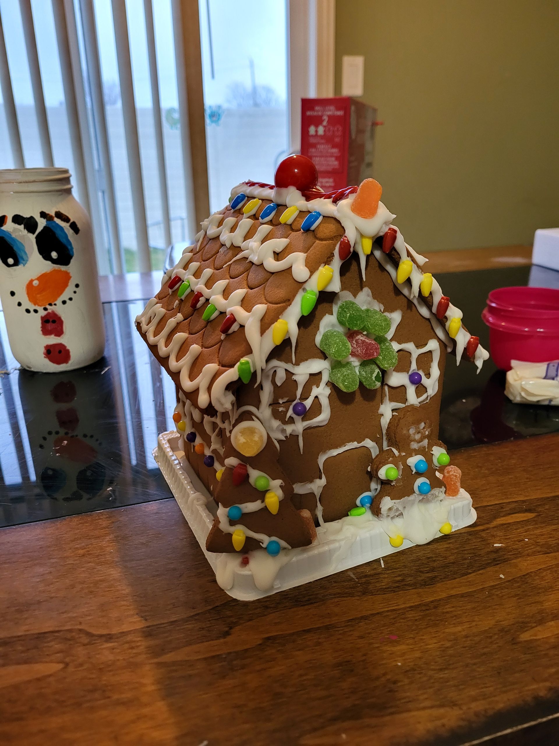 A gingerbread house is sitting on a wooden table.