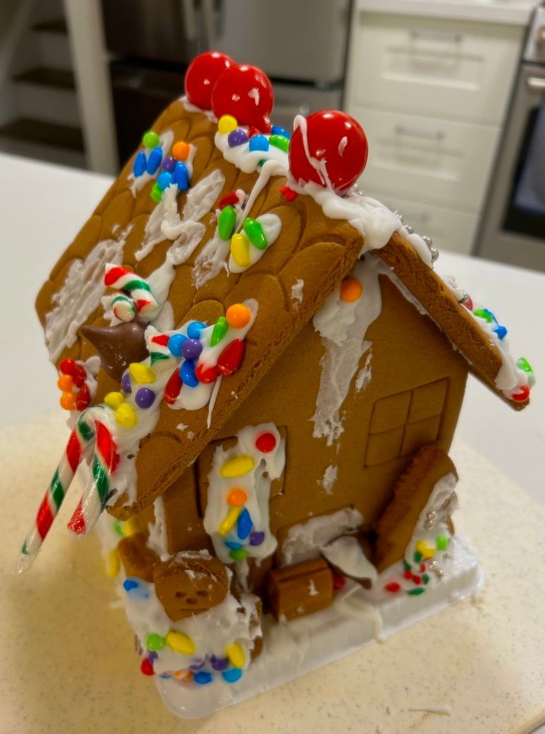 A gingerbread house with candy canes on top of it