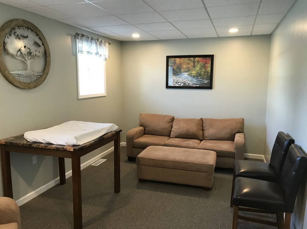 A living room with a couch a table and chairs